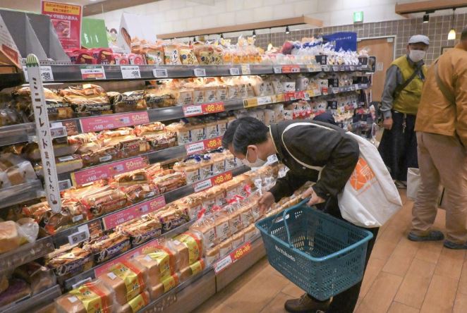 A shopper looks at products at a supermarket in Tokyo on May 2, 2022. (Kyodo)